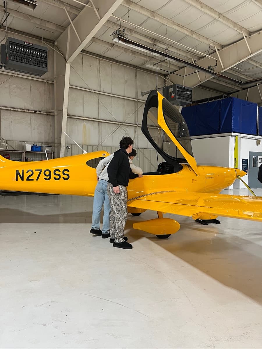 Two people looking over a Bristell in the hangar before a flight