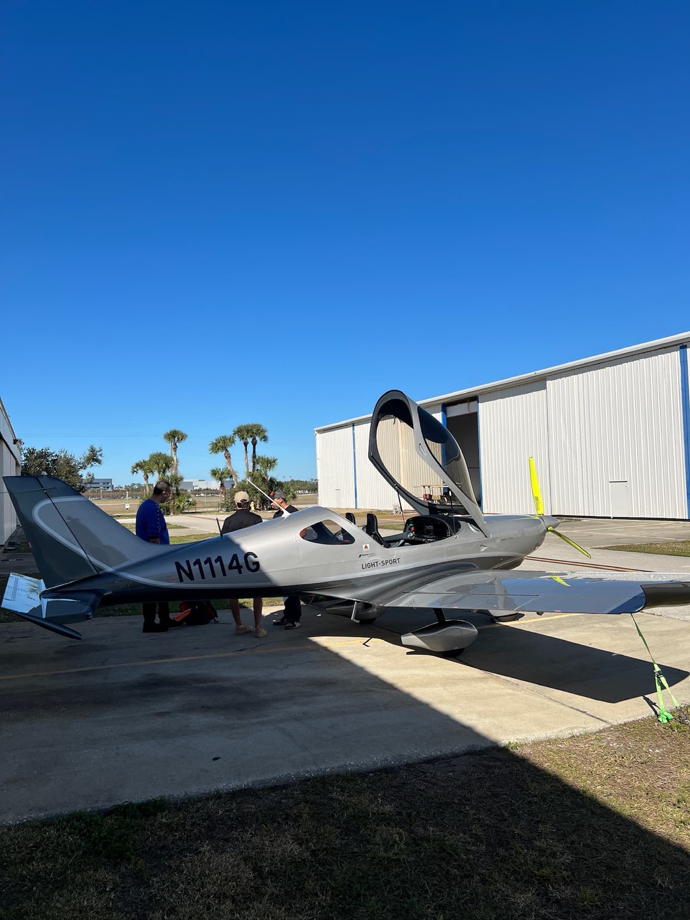 A silver Bristell on the ramp under a clear blue sky