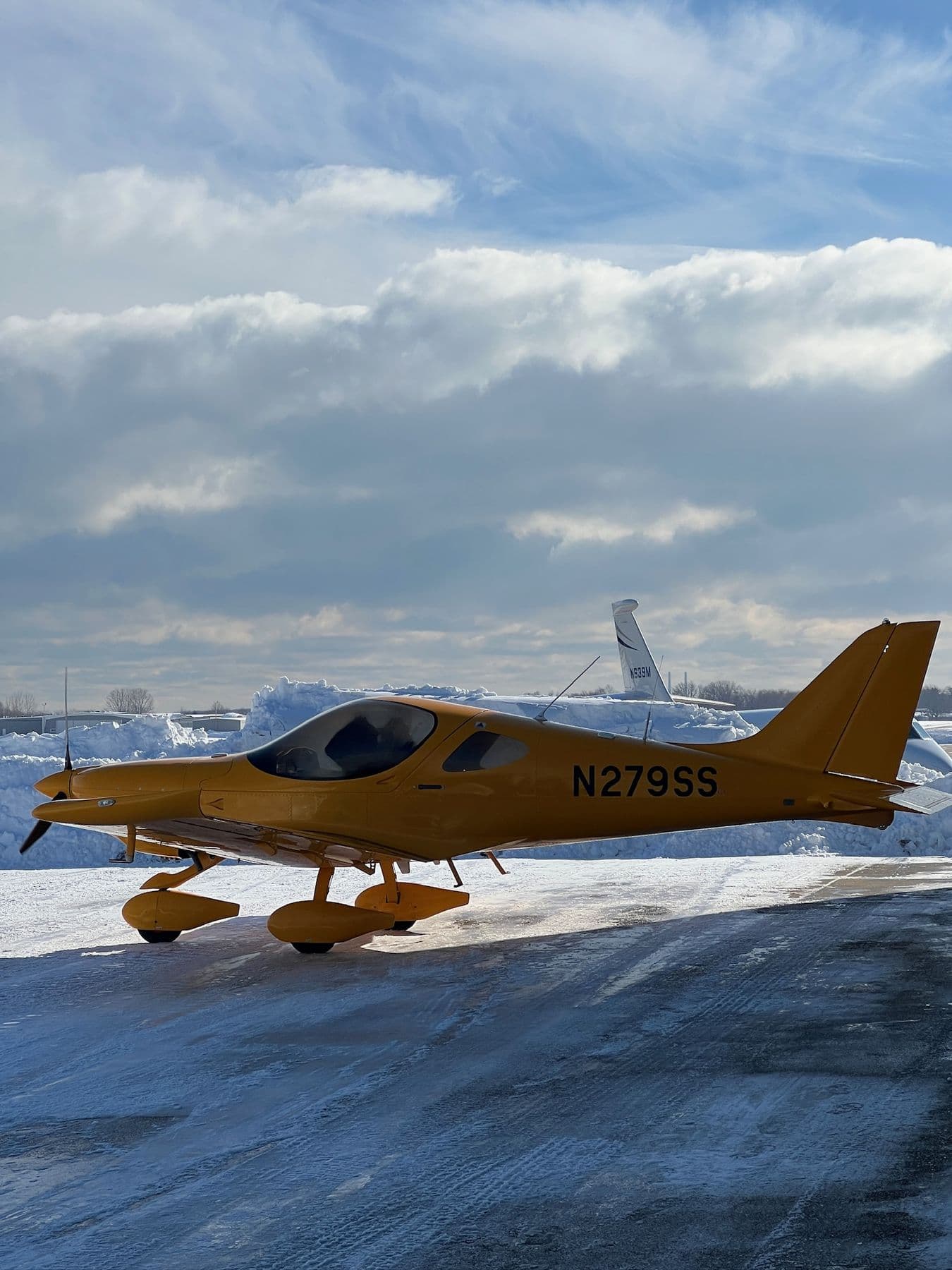 The yellow Bristell N279SS on the ramp under heavy cloud