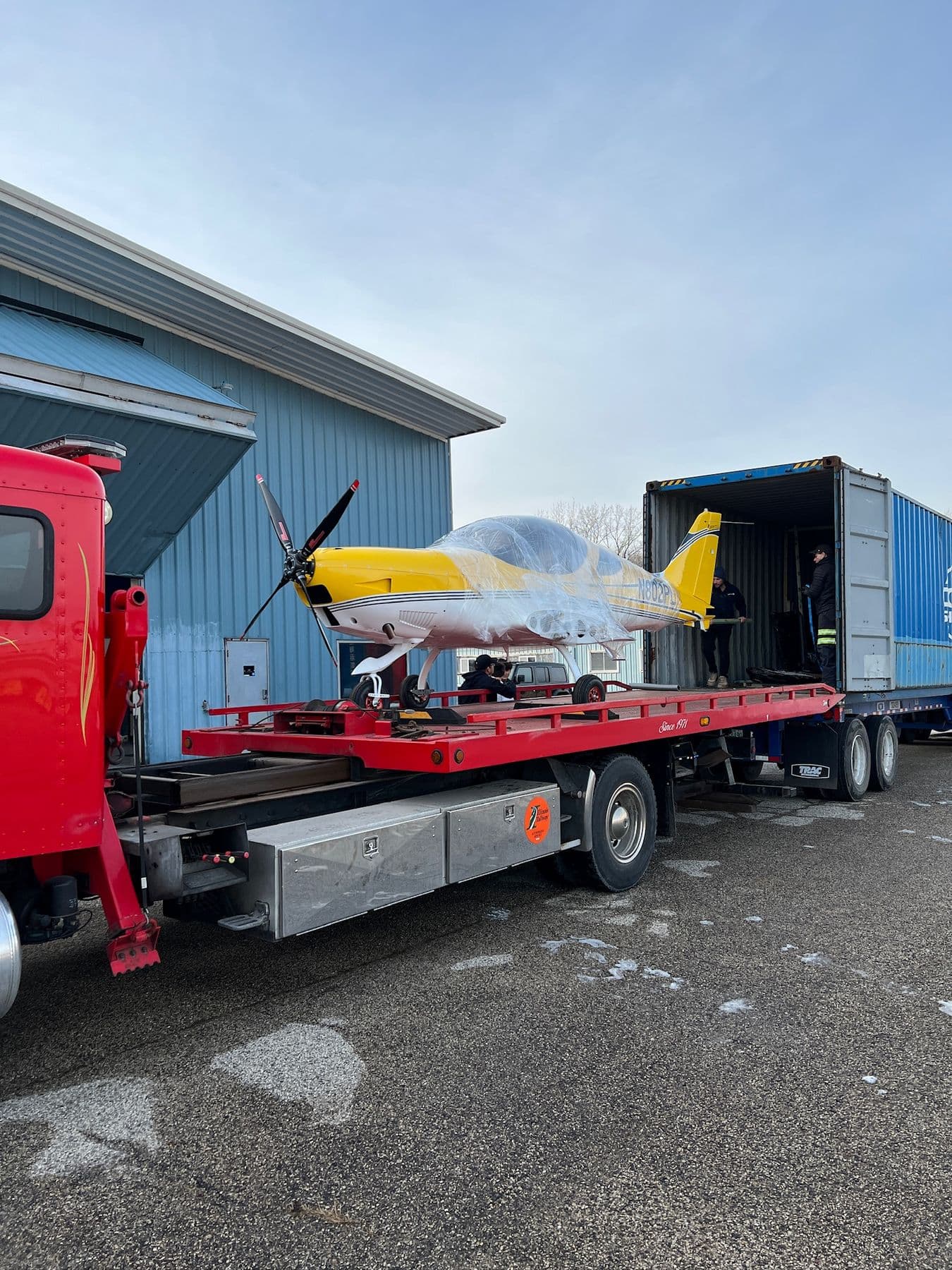 A yellow Bristell being loaded onto a flatbed truck